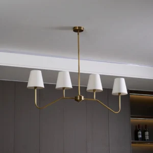 Diana mid-century linear chandelier overhead view in dark kitchen with wooden cabinets, warm brass finish