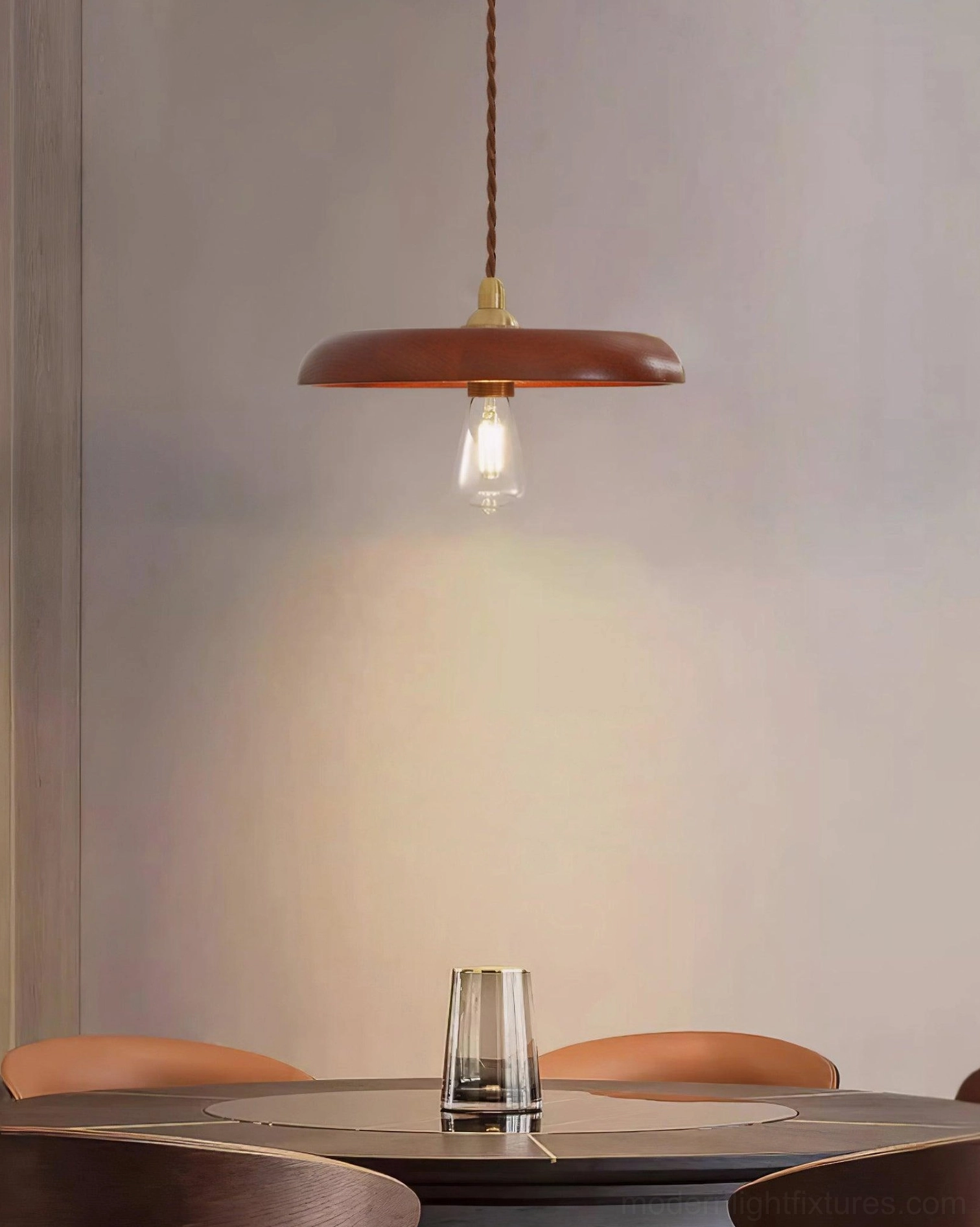 Wood pendant light suspended above round dining table creating warm dining room ambiance