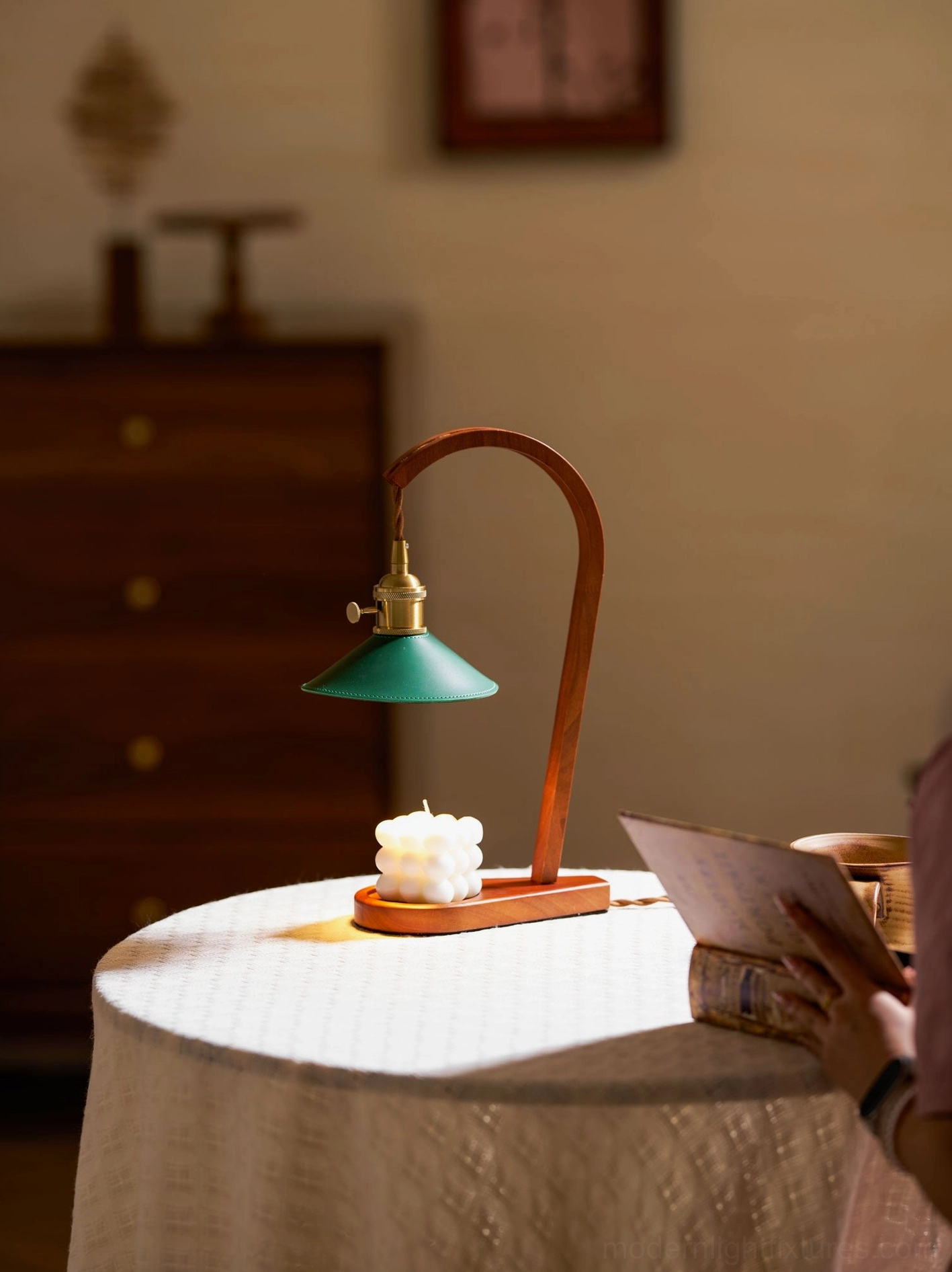 Diosa candle warmer lamp dining table ambiance with person reading and warm brass wood color