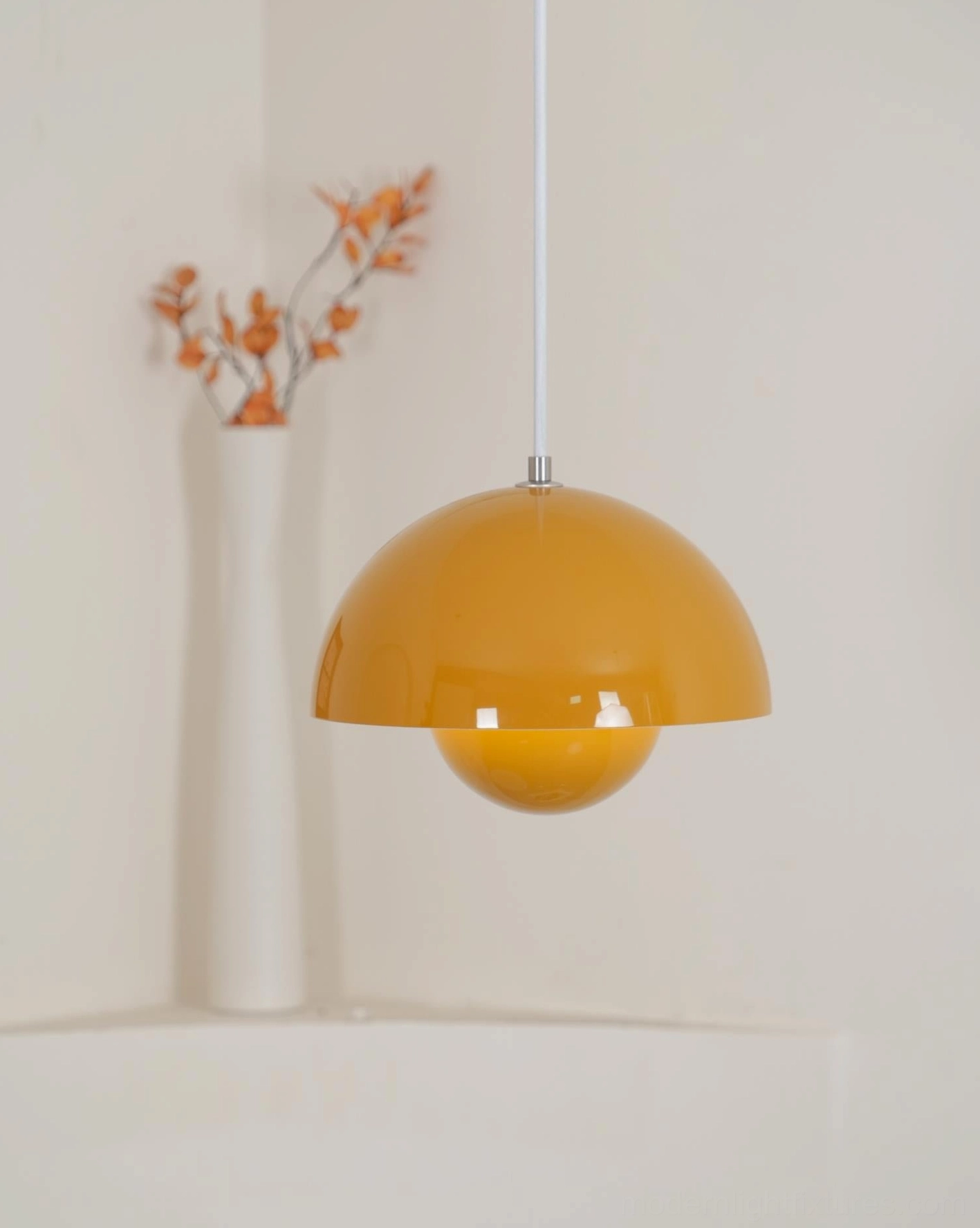 Contemporary dome pendant lamp with warm yellow metallic finish displayed on windowsill