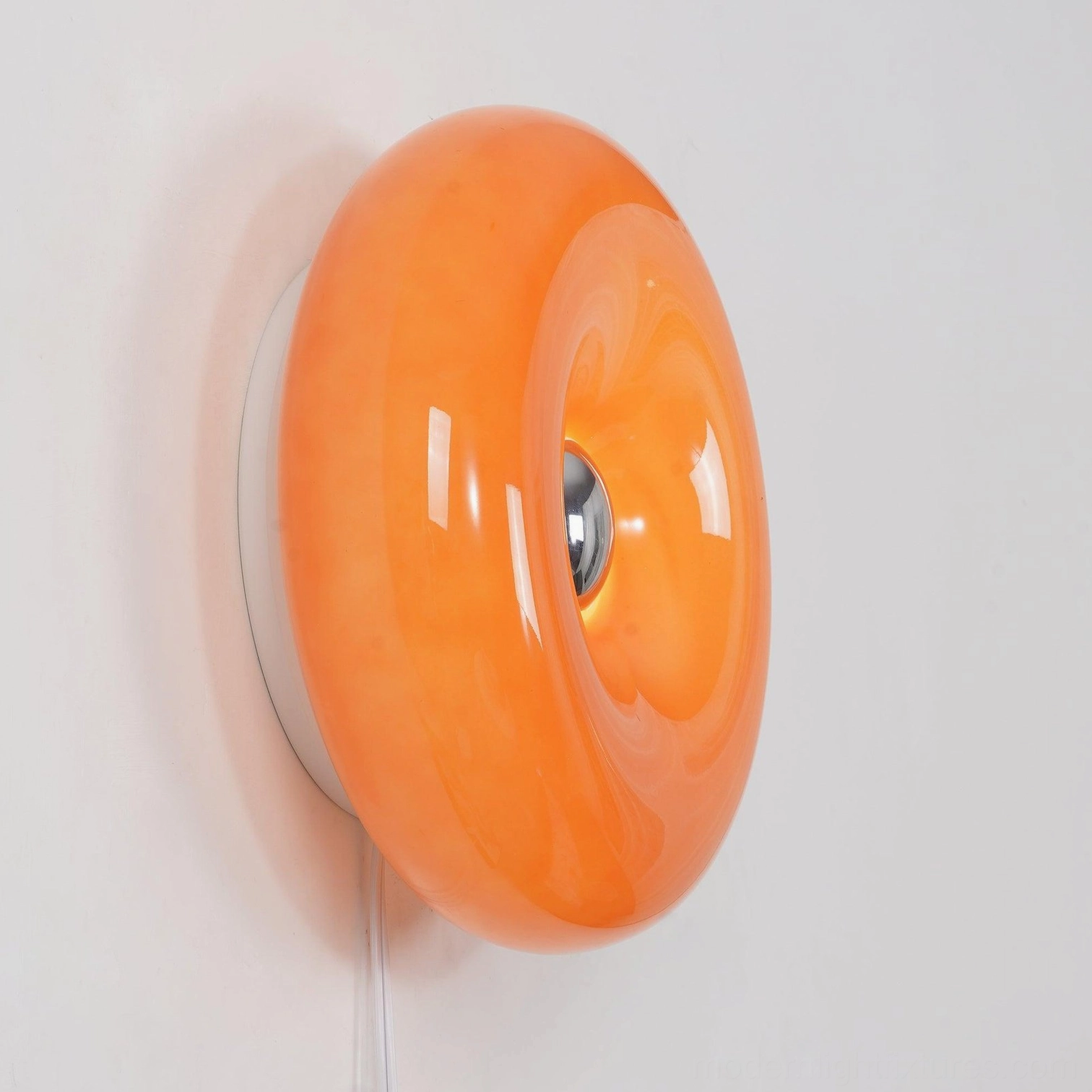 Donut wall sconce in warm orange with integrated LED technology, front view product shot
