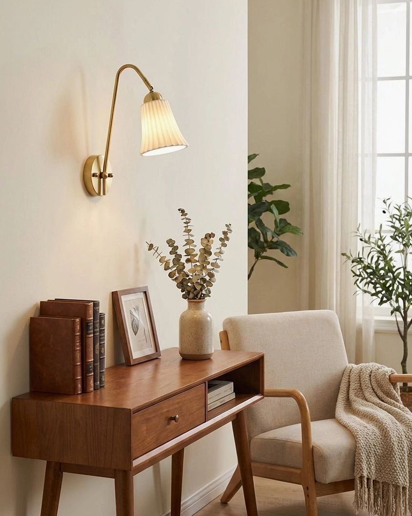 Dorelia wall sconce mounted in home office vanity corner area with brass finish and pleated ceramic shade