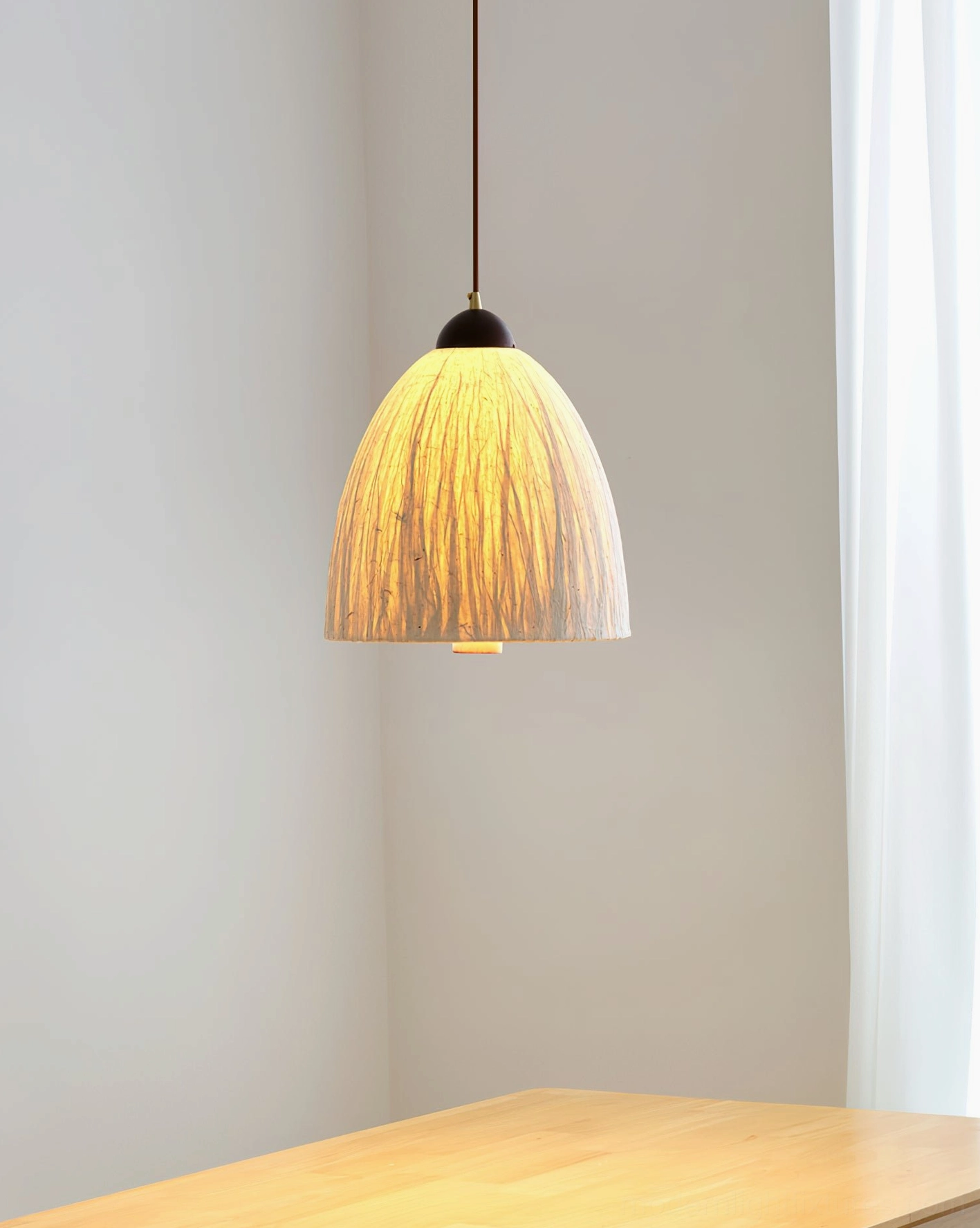 Pleated fabric dome Doria pendant light illuminated in dining area, soft warm white light diffusion