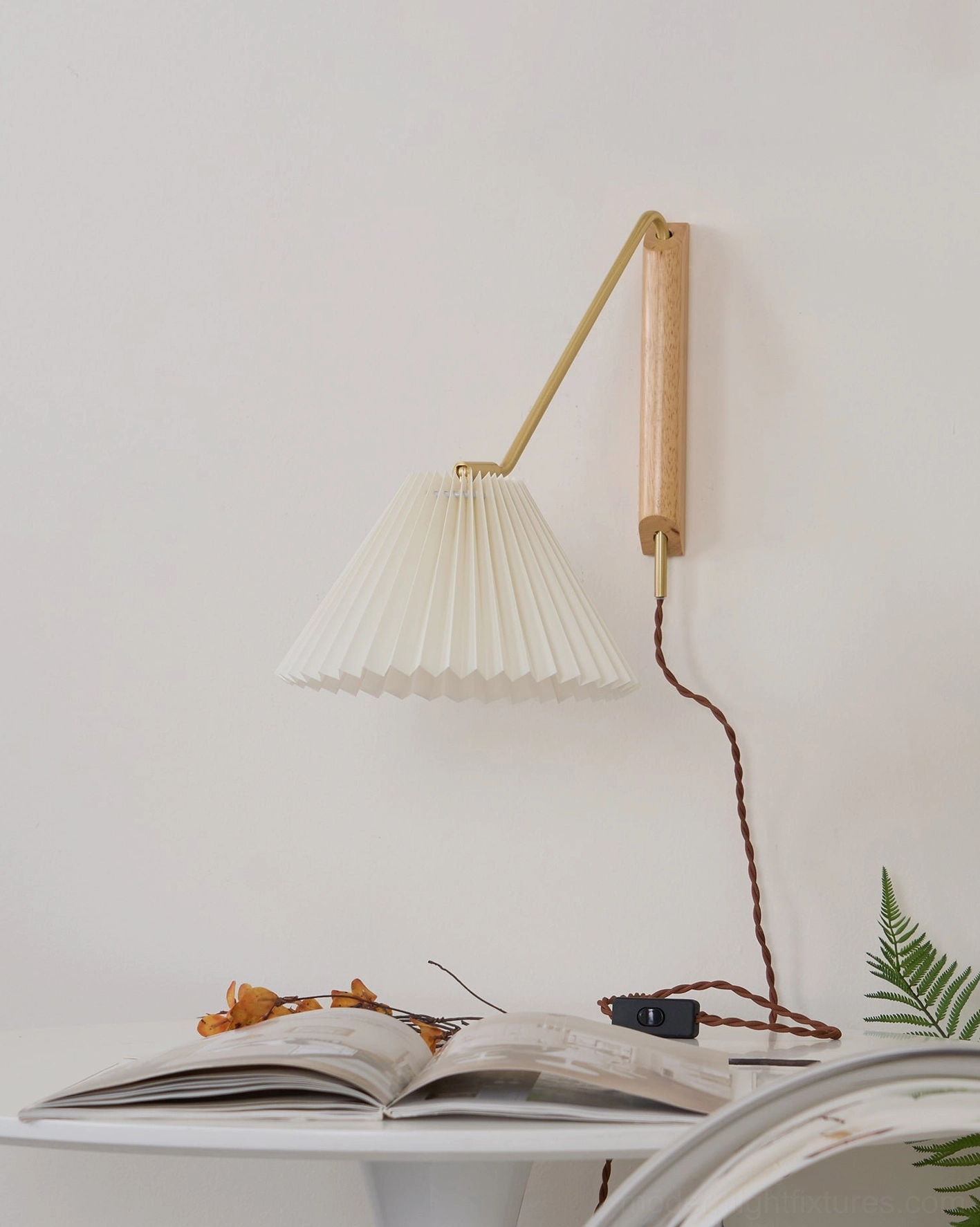 Dorset wall lamp showing brass arm and wooden mounting plate in close view