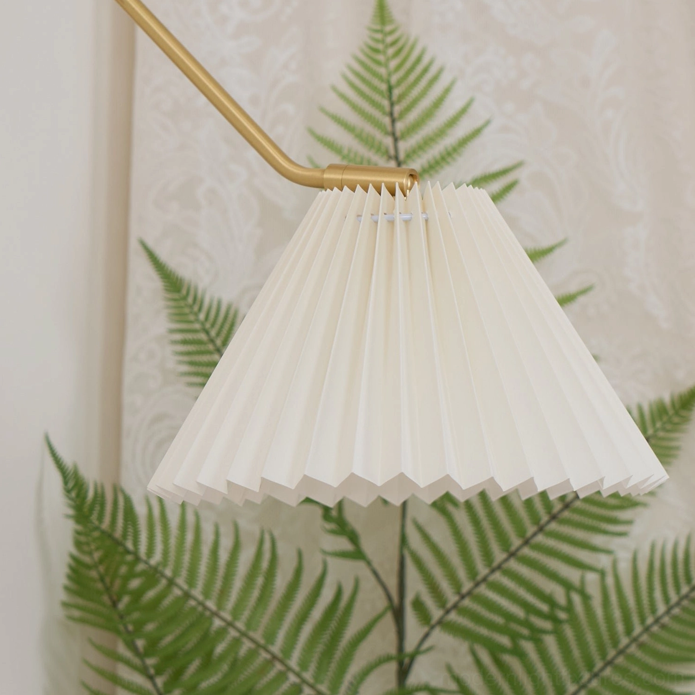 Dorset wall lamp installed at eye level showing pleated shade and adjustable positioning