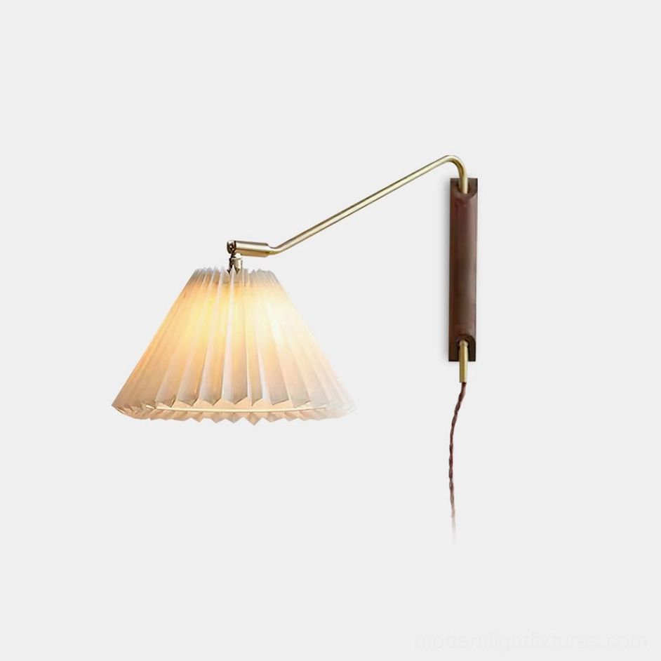 Dorset pleated wall sconce with brass adjustable arm and wooden base in studio view