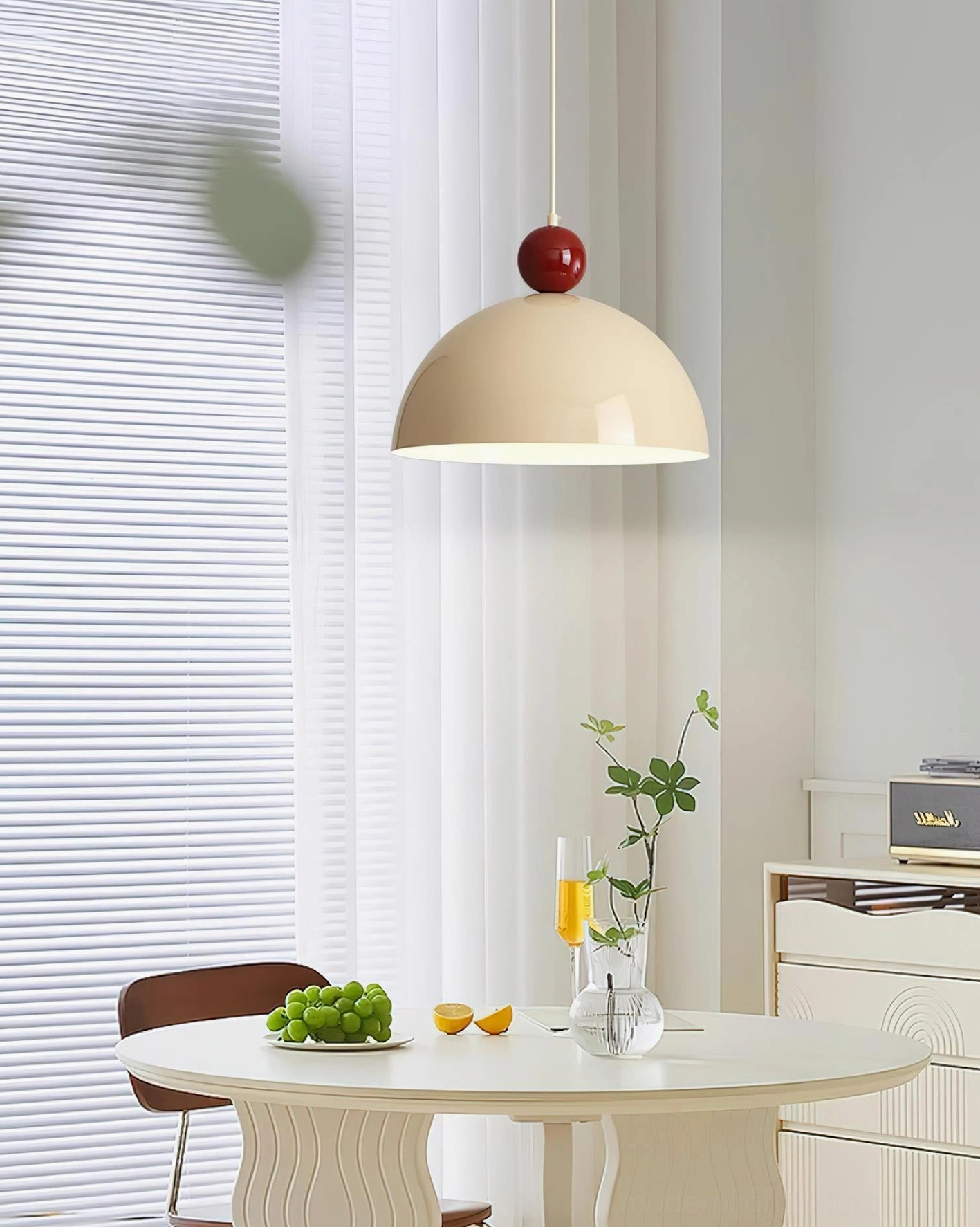 Dotto cream matte dome pendant lamp with red accent ball, low angled view in bright dining area showing contemporary home style