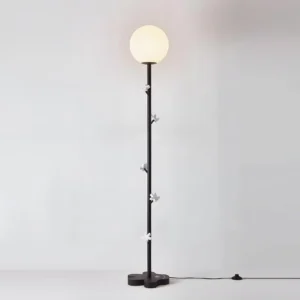 Black metal floor lamp with flower-shaped base and multicolor bead details, milky white globe light shade, contemporary Nordic style