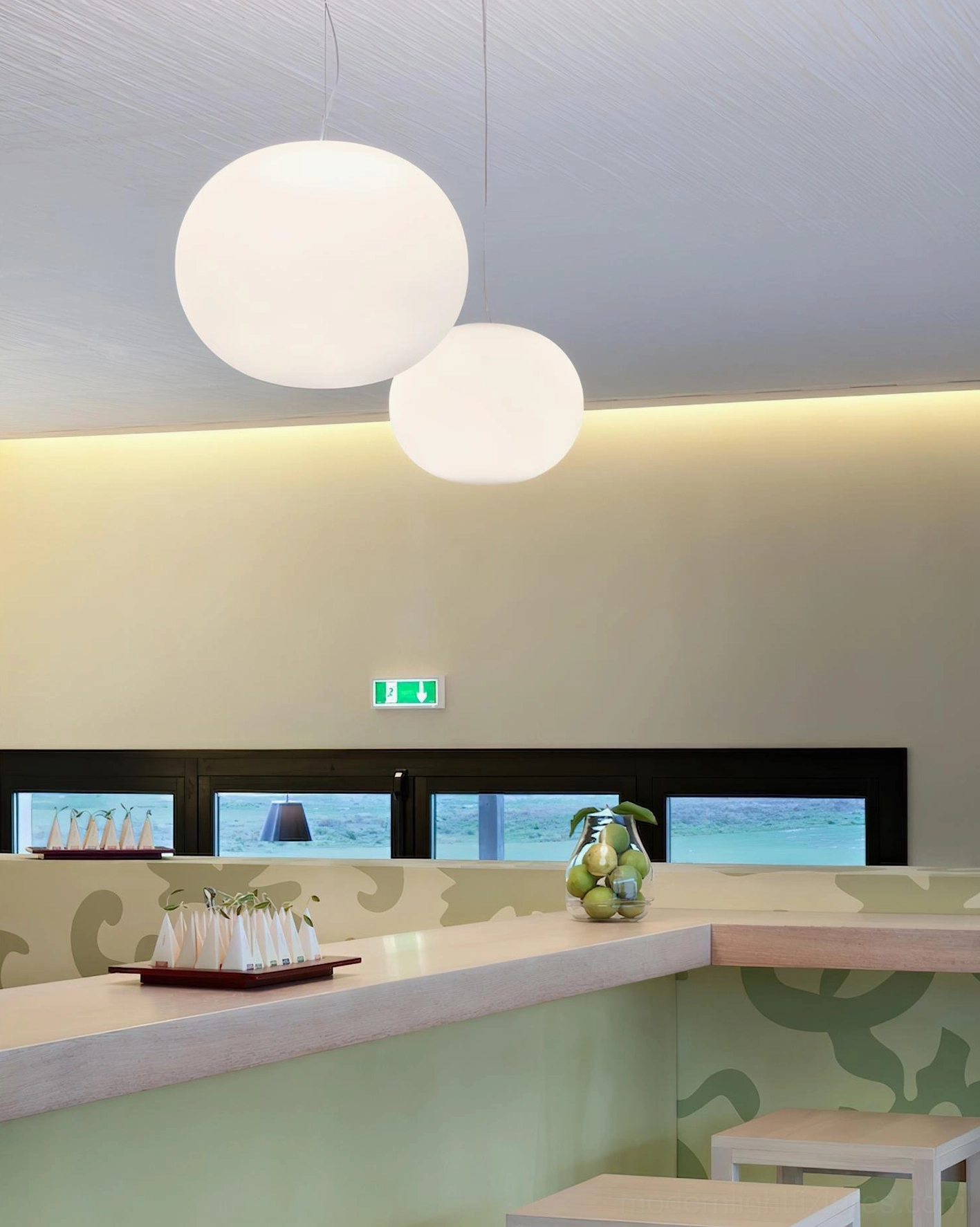 Dual frosted glass sphere pendant lights above kitchen counter - two white pendant lamps in warm minimalist dining area