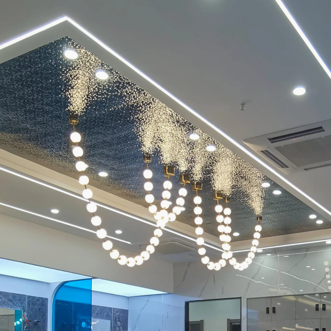 Double-height commercial lobby pearl string chandelier with illuminated acrylic spheres and sparkling light effects