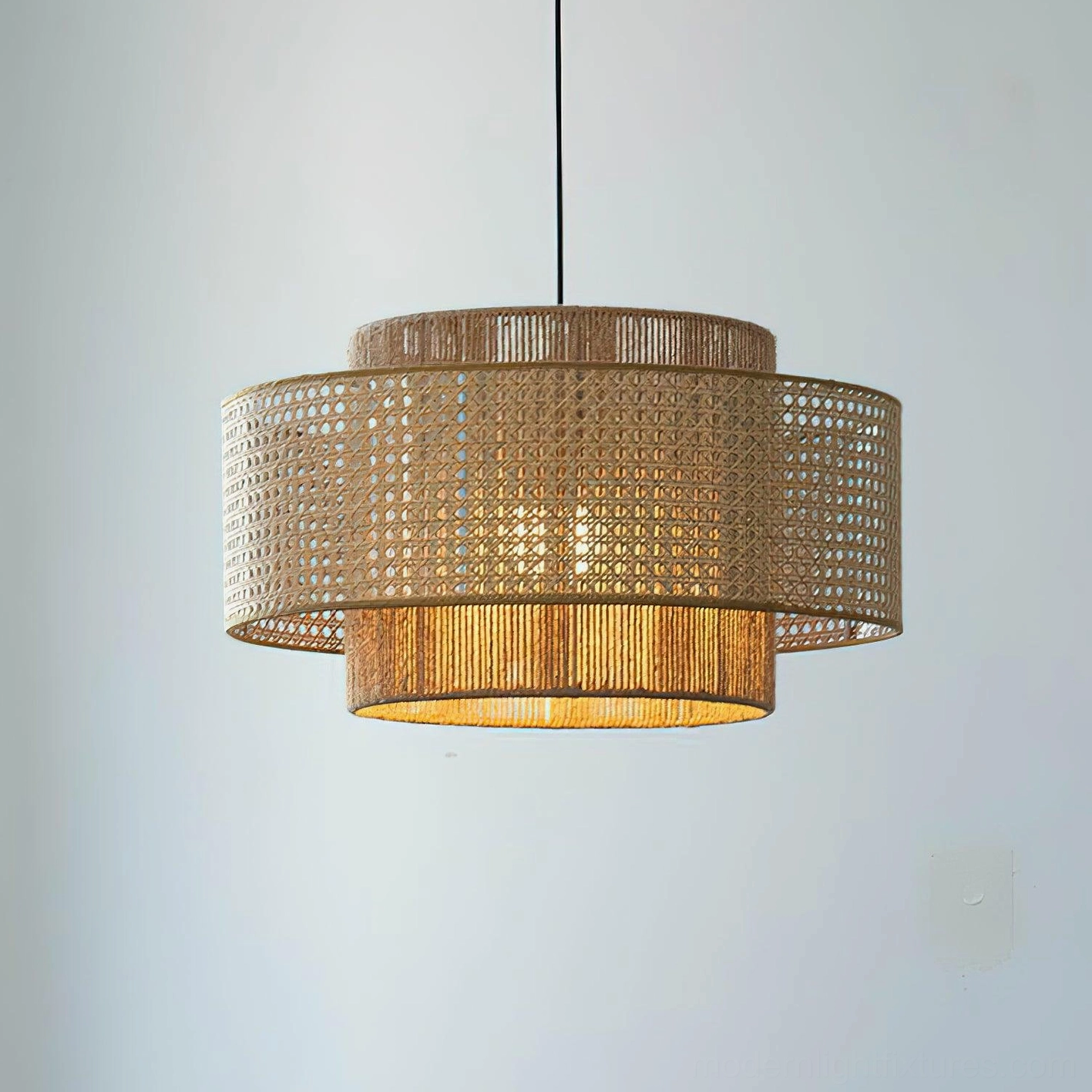 Double-layer woven rattan pendant lamp front view against light gray wall, showcasing two-tier hollow weaving structure and warm light diffusion