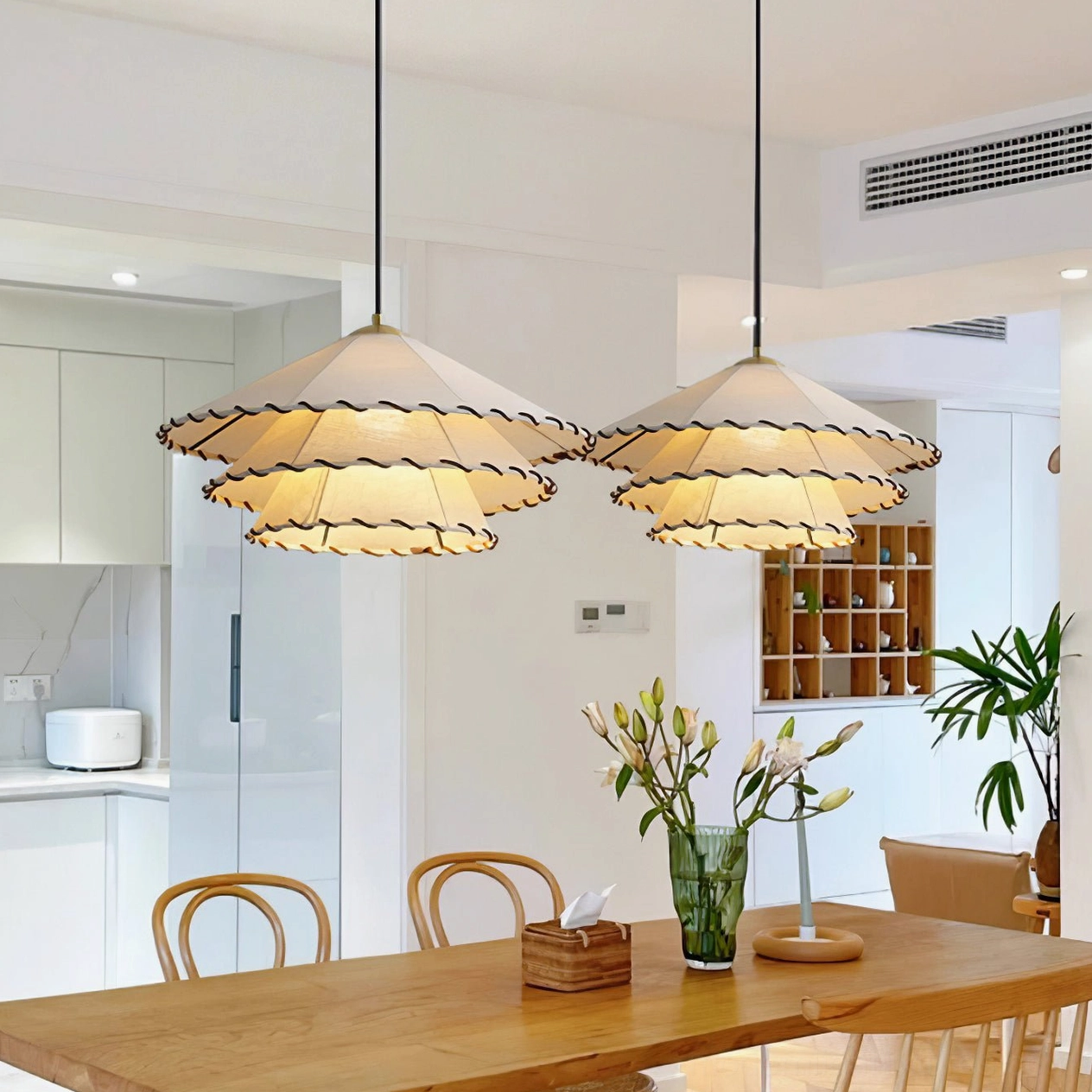 Two matching handwoven fabric pendant lights in warm dining space with wooden table, modern Japandi interior design