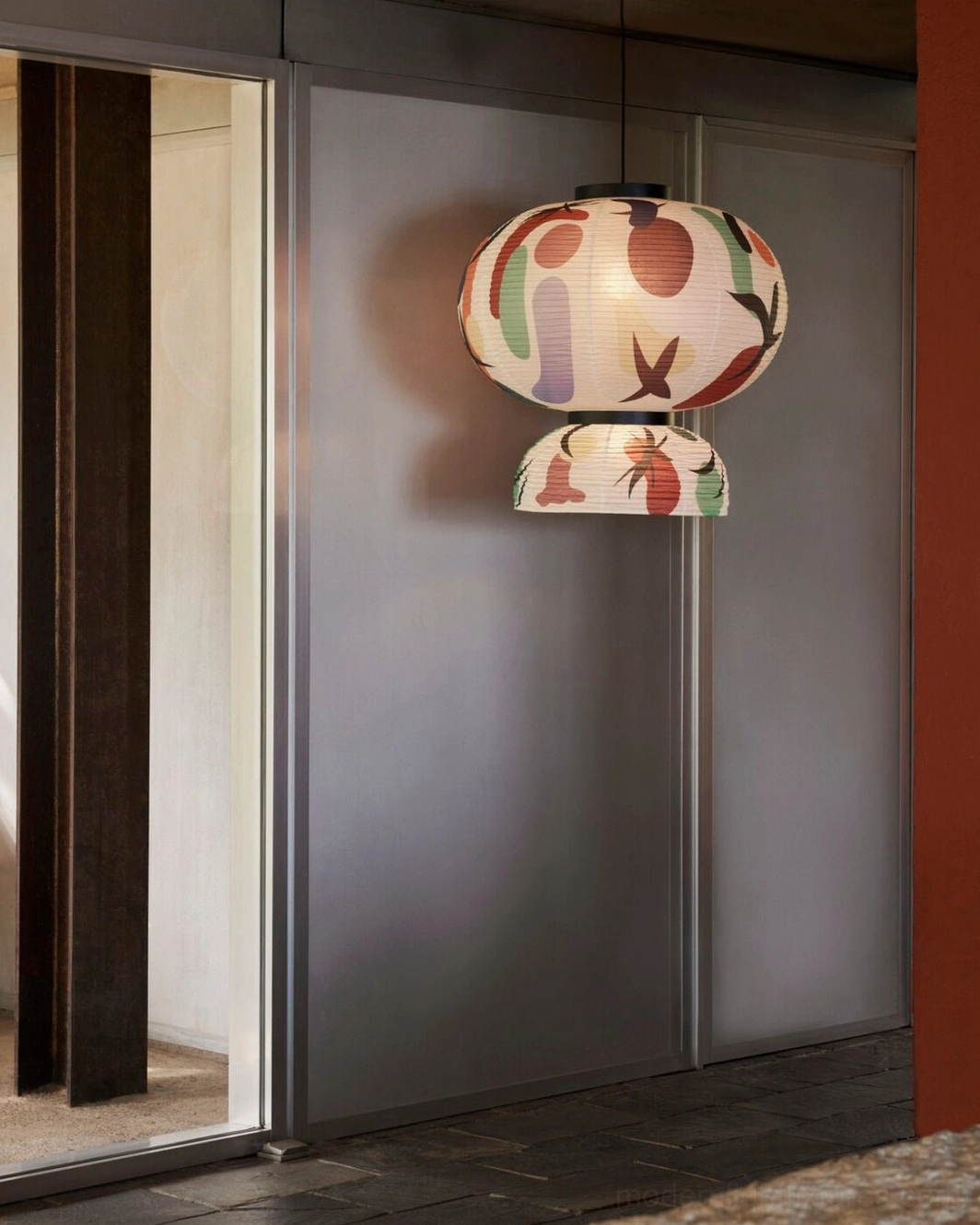 Double-tier printed paper pendant lamp side view in modern entryway with frosted glass room dividers and abstract graffiti print design