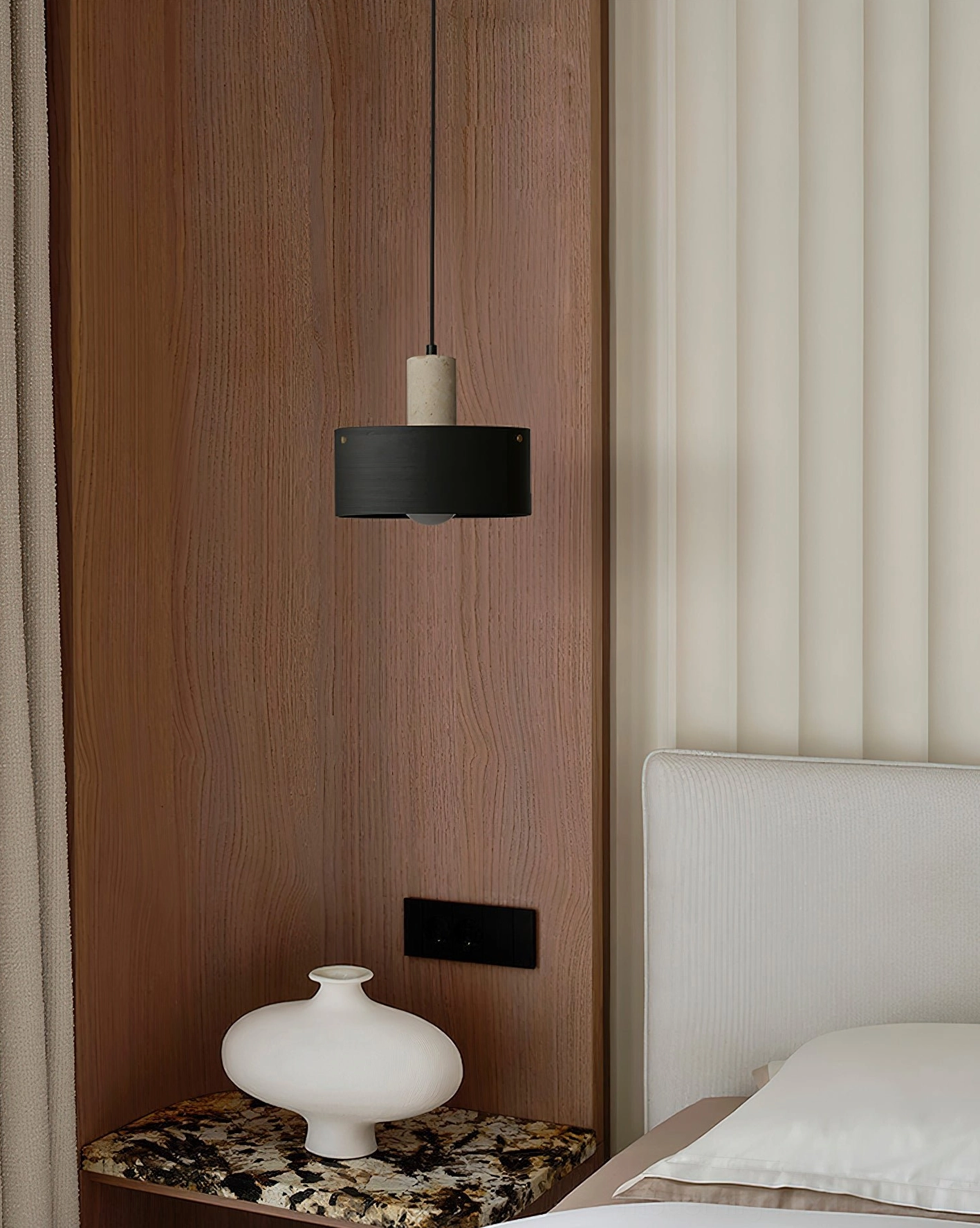 Matte black Dovira drum pendant light hanging above bedroom nightstand as modern minimalist bedside illumination solution