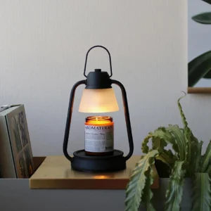 Modern candle warmer lamp displayed on shelf with branded candle jar warm ambient lighting