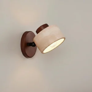 Modern natural stone wall sconce with dark wood base, side profile showcasing textured matte travertine material
