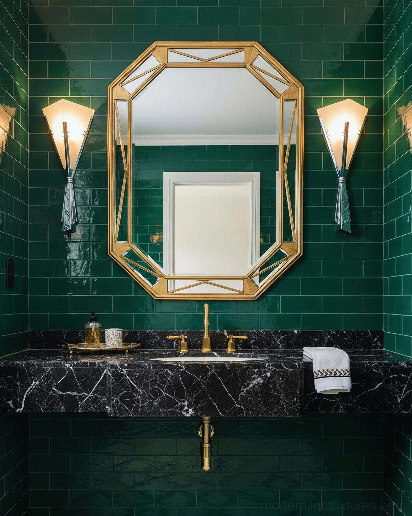 Matching pair of Art Deco wall sconces above bathroom vanity with dark green tile wall and marble countertop, gold accent details