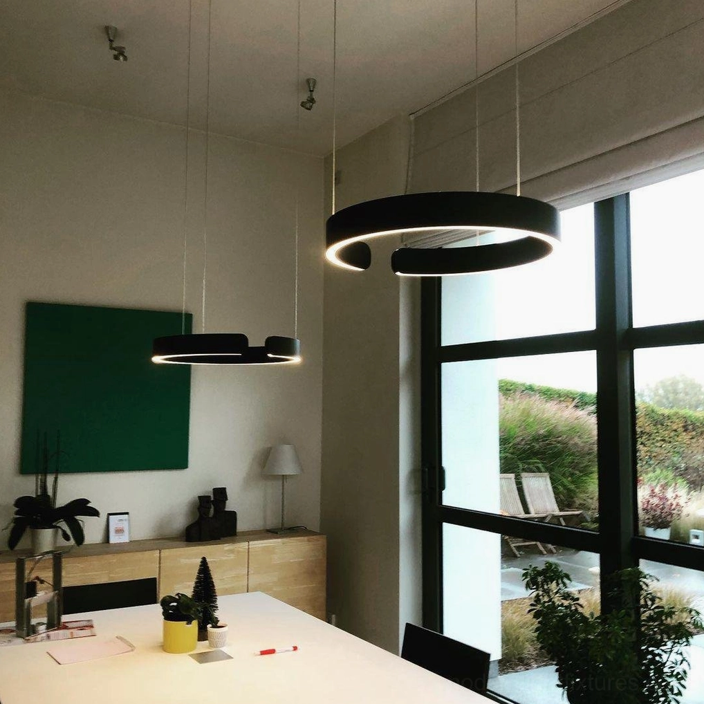 Dual black halo ring LED pendant lamps in minimalist modern home office and dining space with warm ambient glow