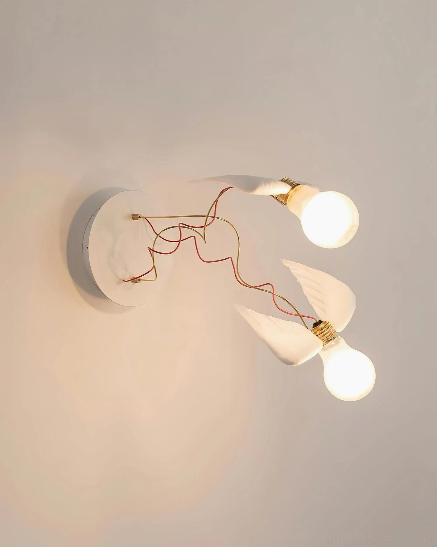 Dual-head feathered wing wall sconce with exposed copper wires on beige wall, artistic lighting design
