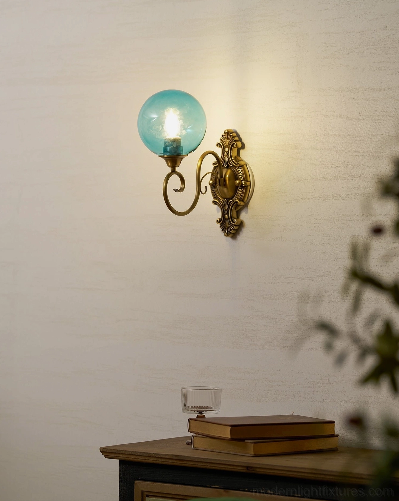 Dual-head ornate brass wall sconce showing both glass globes, baroque vintage wall fixture