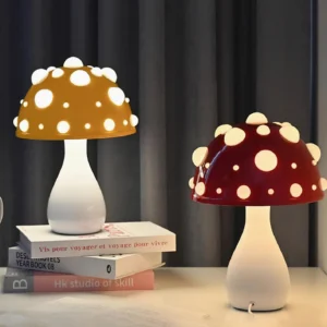 Dual mushroom table lamps with yellow and maroon caps featuring white spots, displayed on home office desk with stacked books and warm ambient lighting