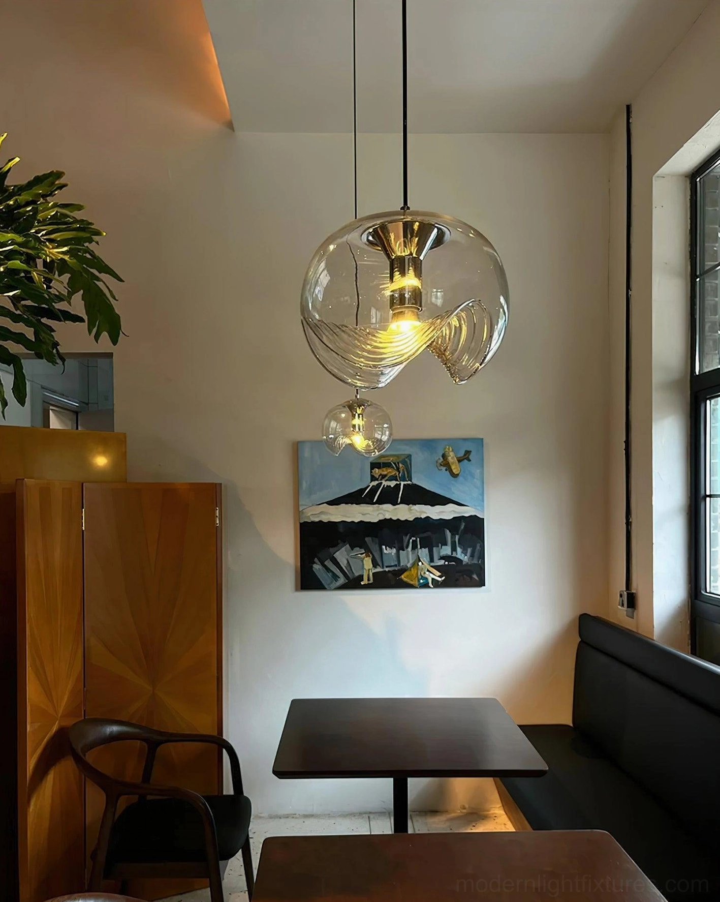 Dual modern pendant lights in cafe dining area, low-angle view demonstrating warm ambient lighting for contemporary interior spaces