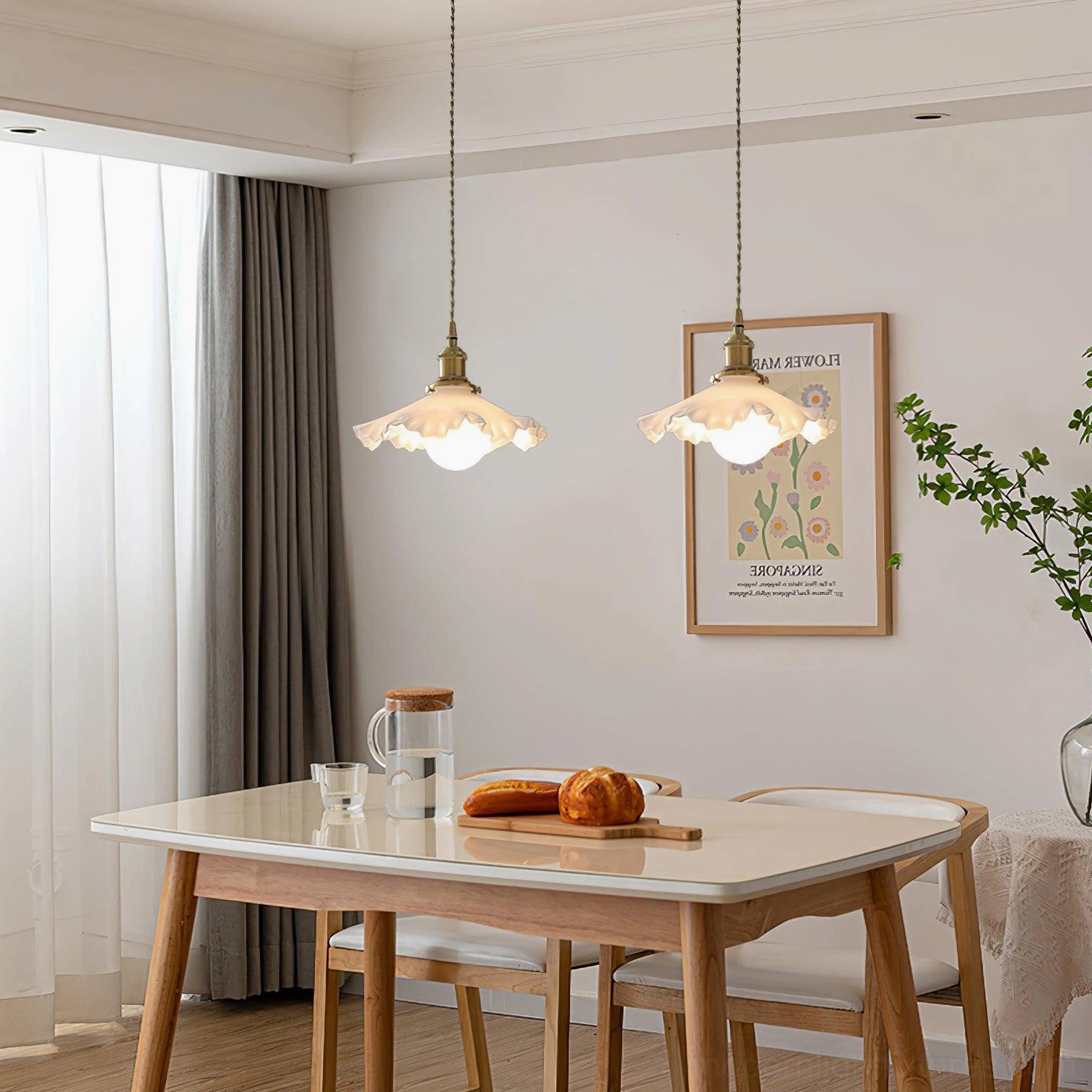 Pair of matching ruffled glass pendant lights installed in modern Nordic dining room with wall art decor