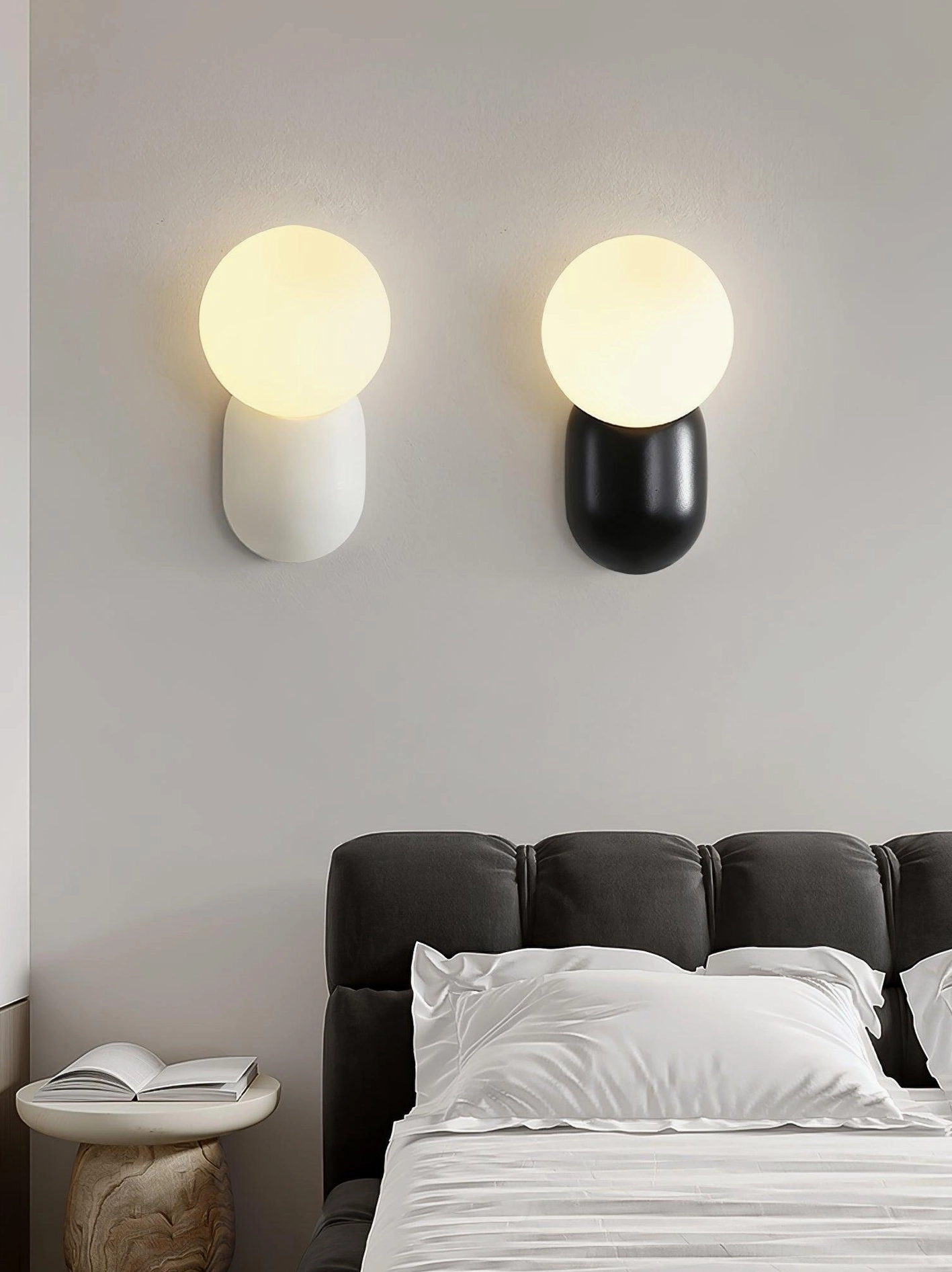 Two modern spherical wall sconces creating layered lighting scheme in contemporary minimalist space