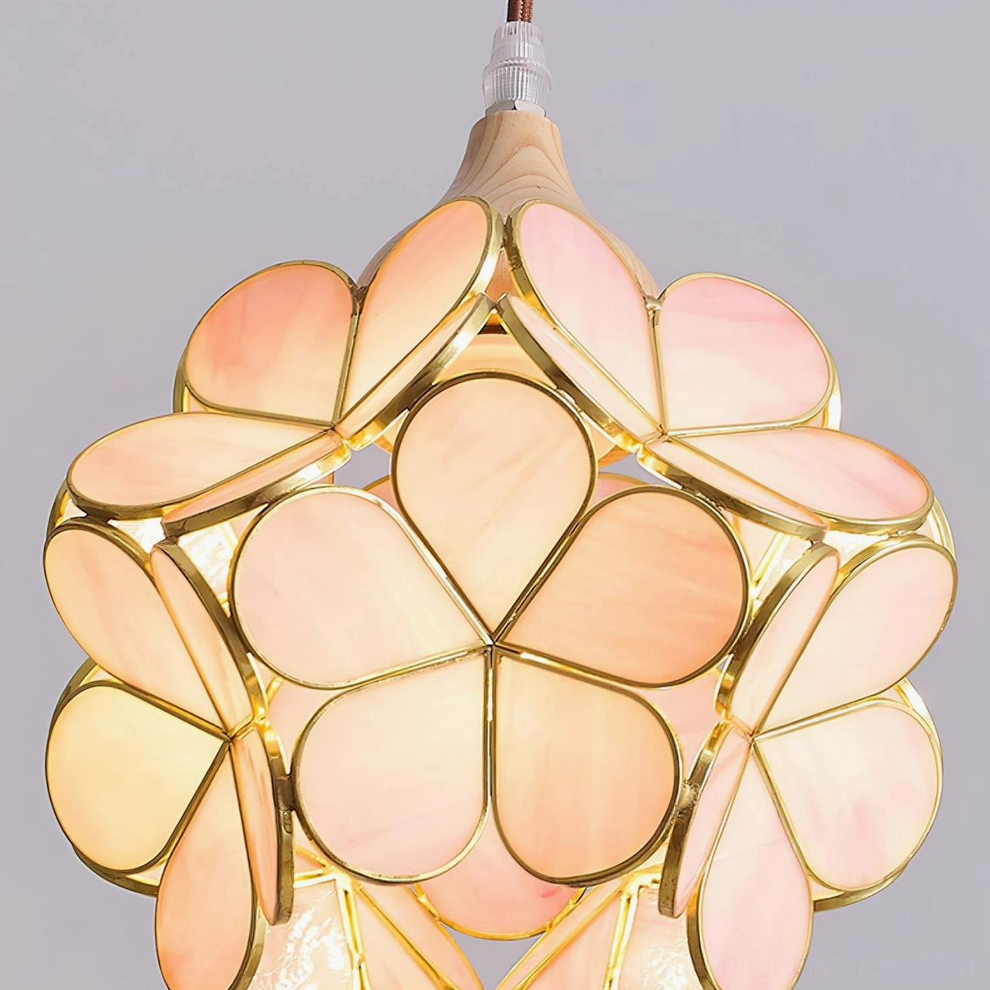 Flower pendant light in eclectic vintage bedroom interior, warm glowing pink shade with artistic flair