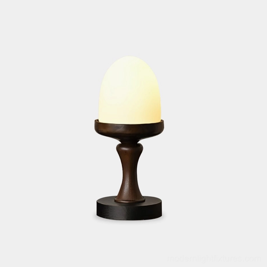 Organic egg-shaped table lamp with dark stained wood base and frosted glass shade, front studio view