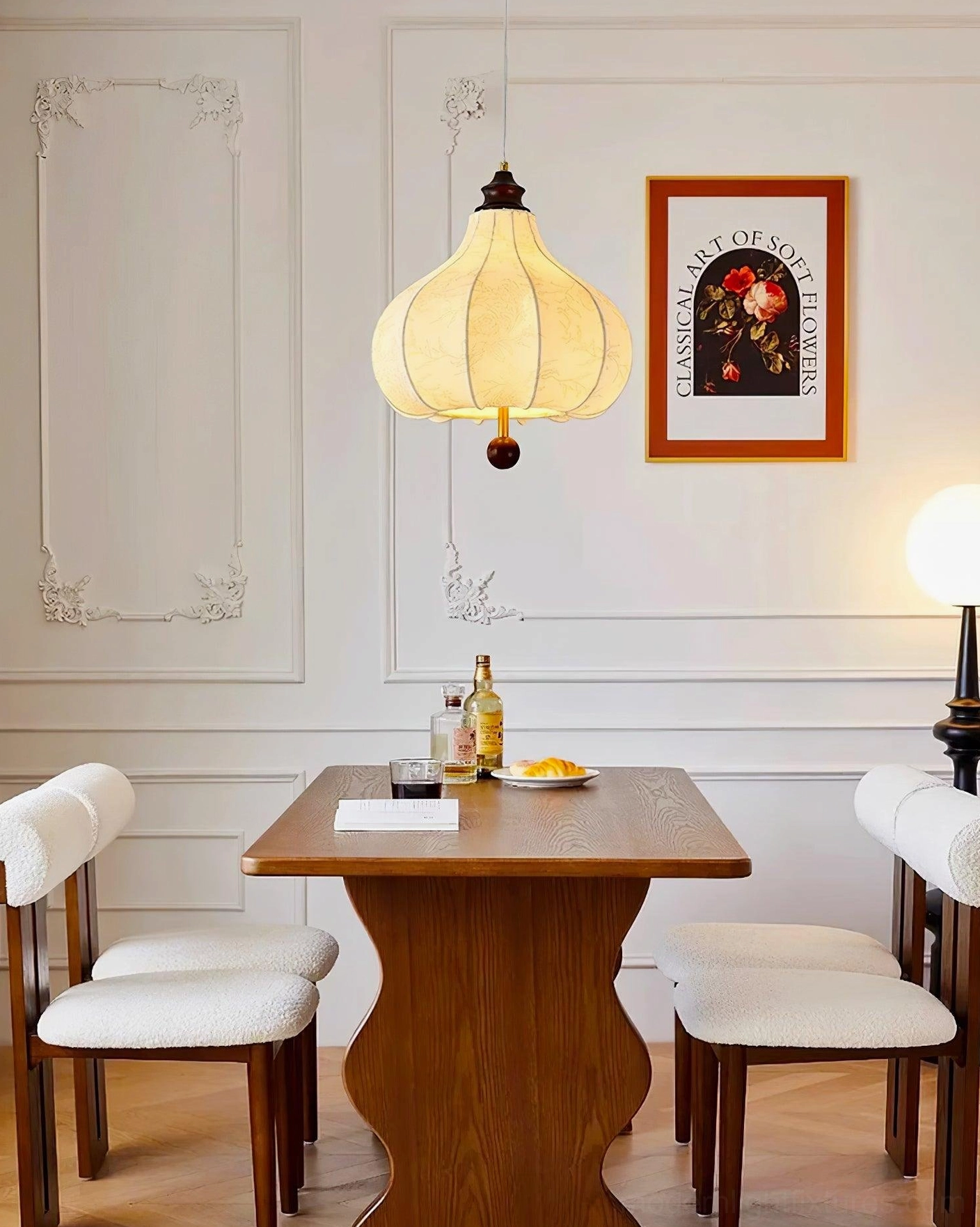Vintage botanical pendant light in elegant dining room with wall moldings, off-white fabric shade and dark metal hardware