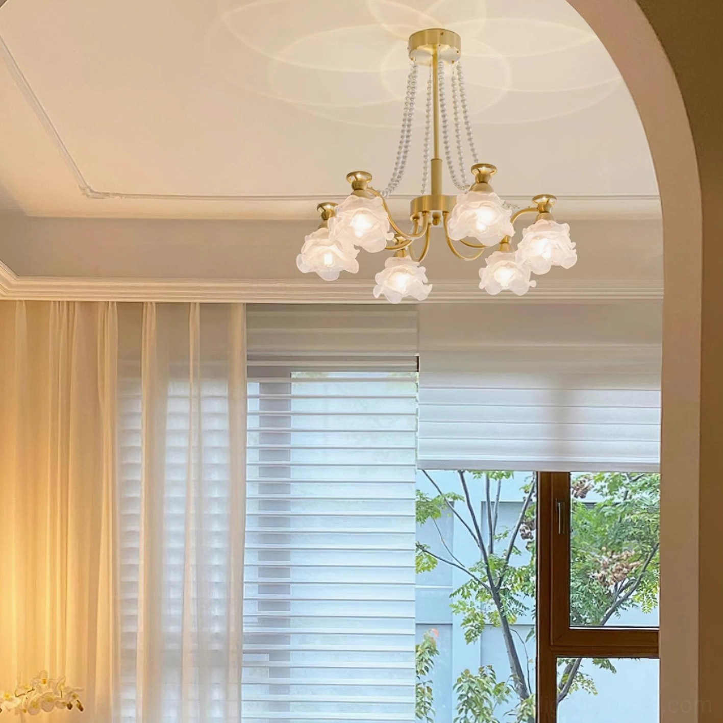 Elegant rose glass chandelier with warm brass tones - transitional interior lighting design