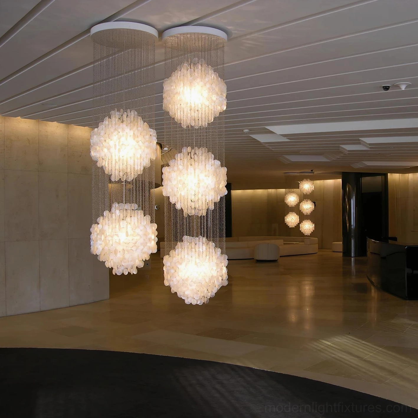 Elegant capiz shell pendant chandelier with metal hanging chains and artistic shell arrangement in neutral space