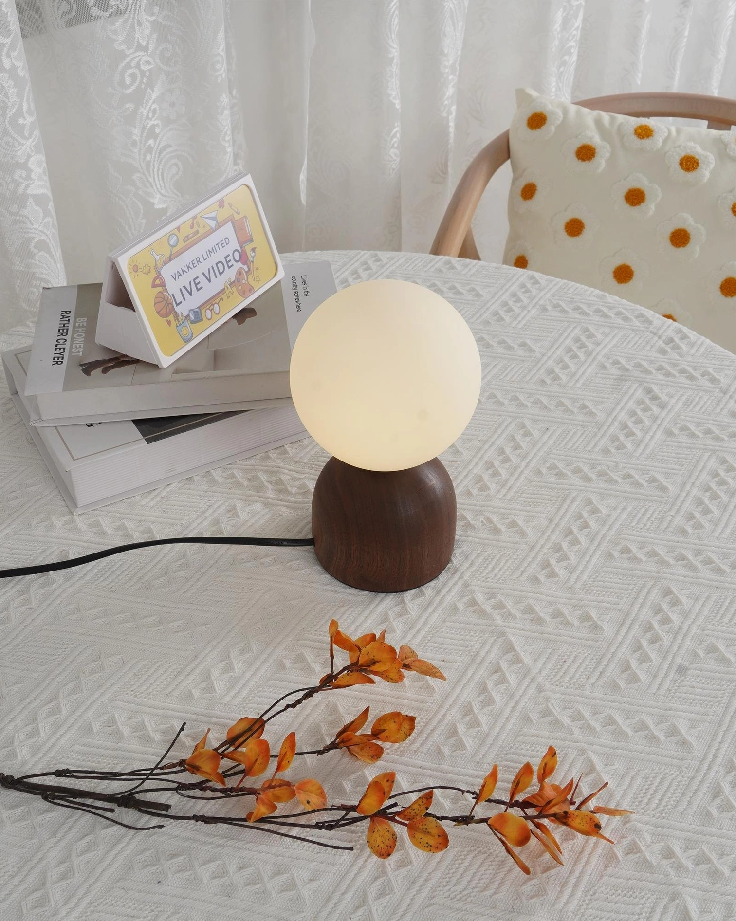 Elegant walnut wood globe table lamp with visible wood grain texture on tabletop with dried flowers