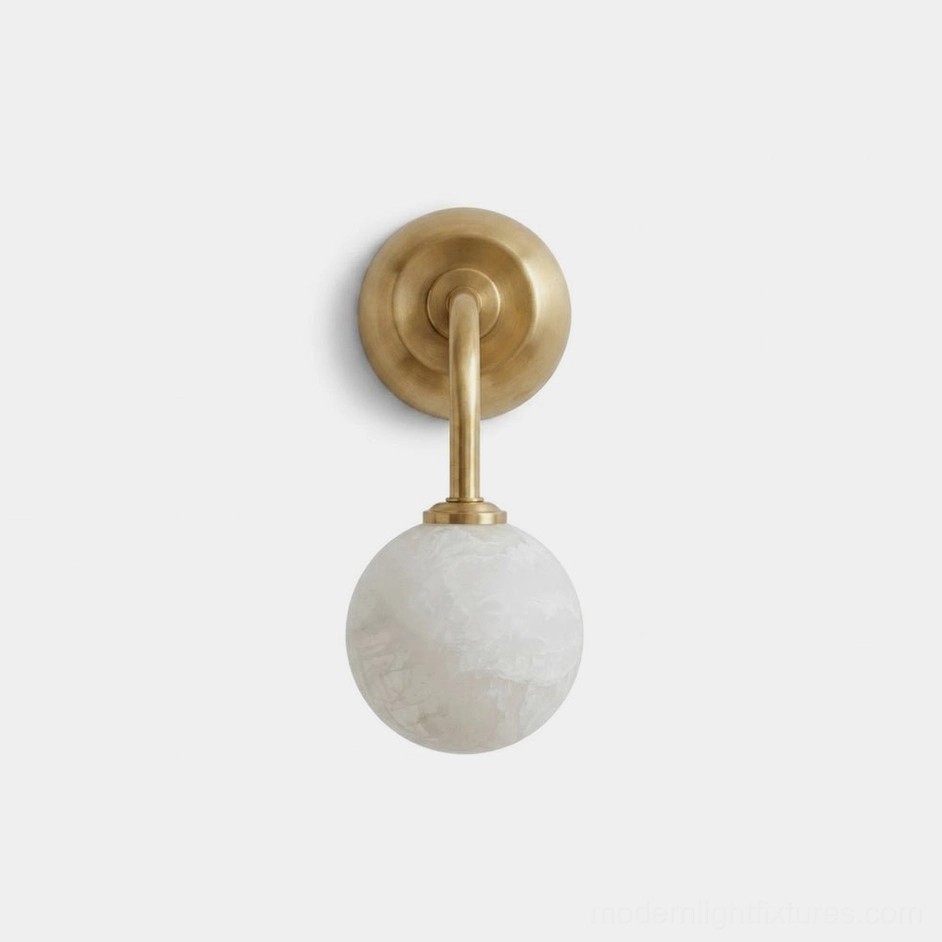 Elio alabaster wall sconce with aged brass curved arm and white marble globe on studio white background