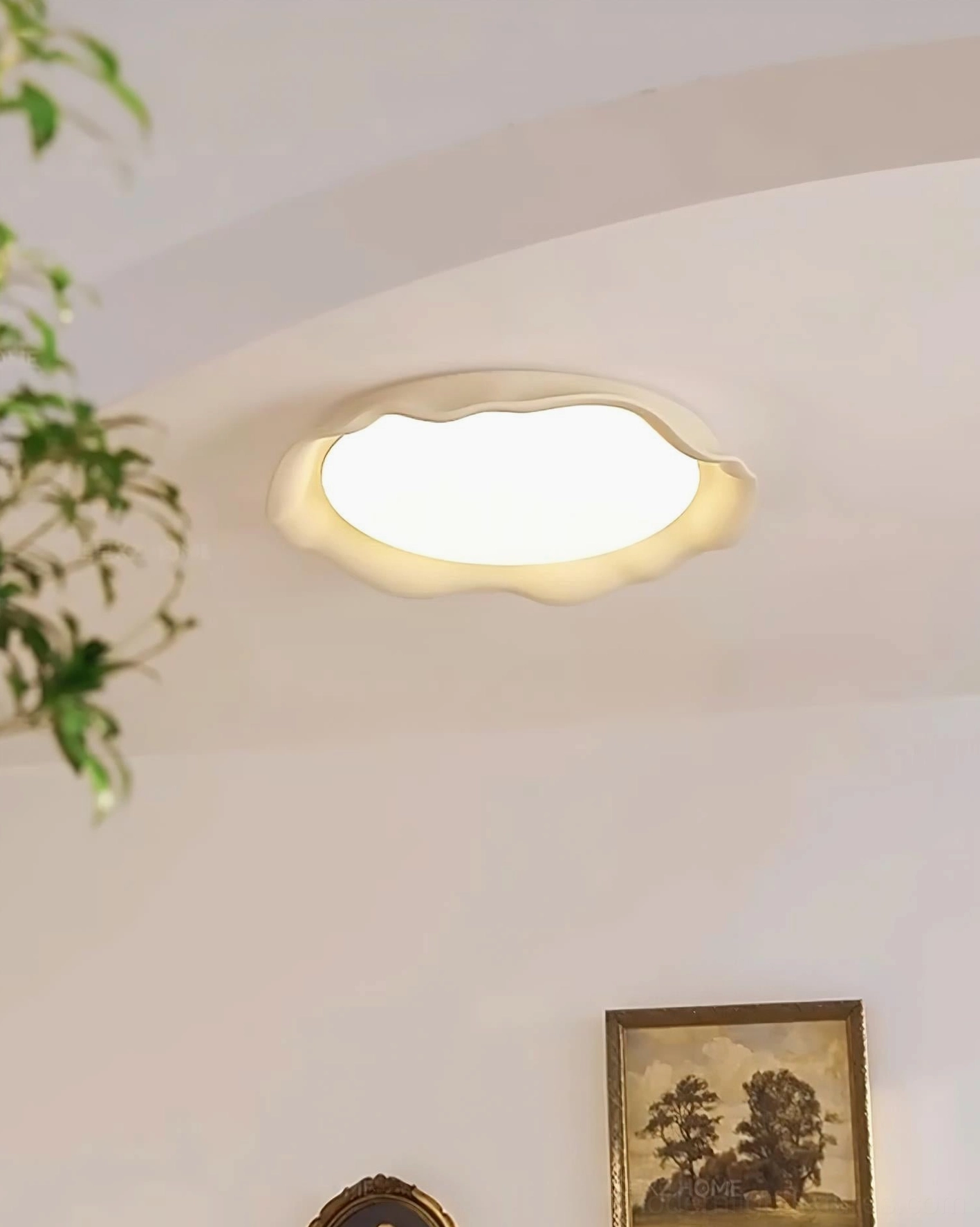 Elio LED ceiling fixture white matte body, warm ambient glow, low-angle view in contemporary living area with wall artwork