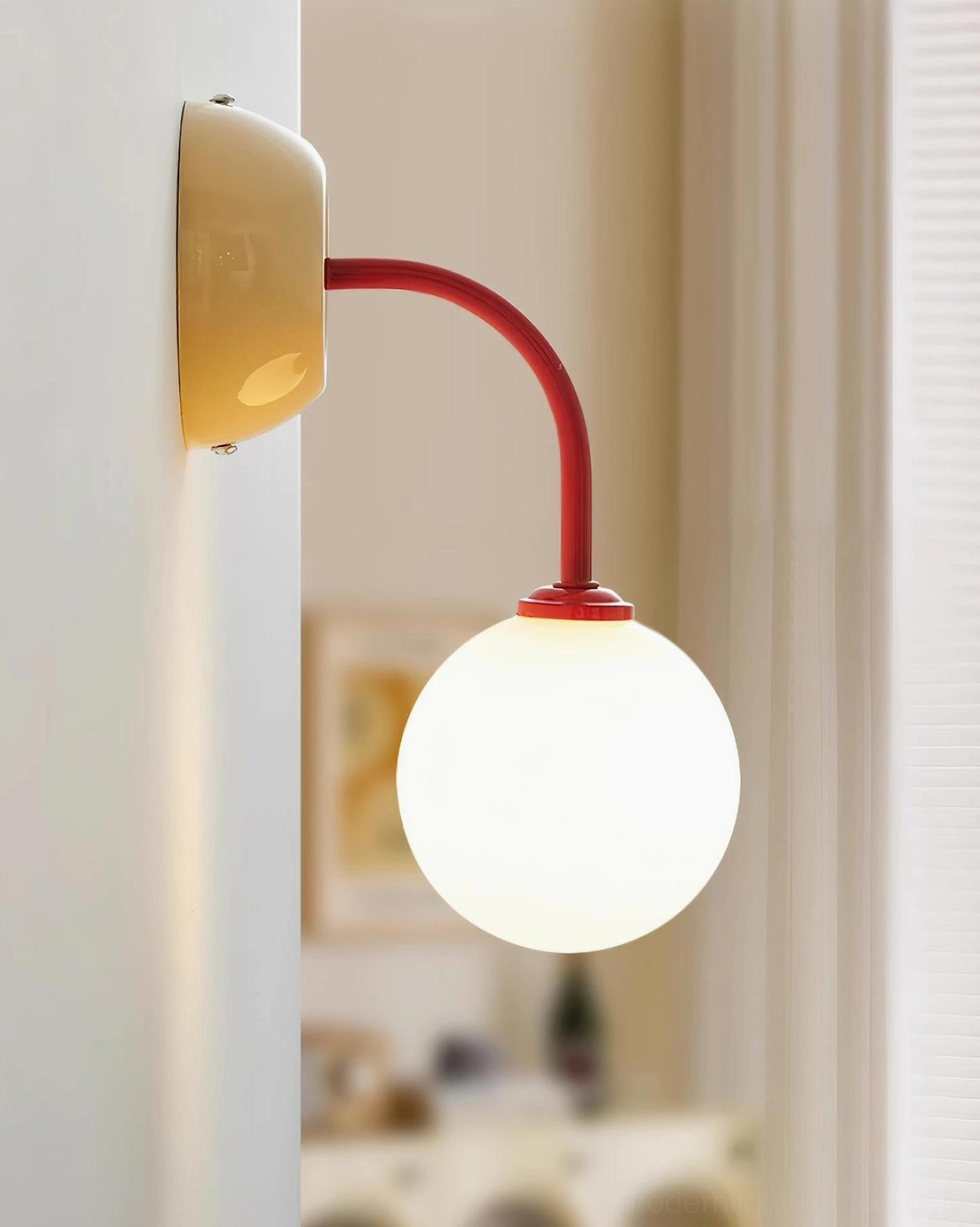 Single Elio wall sconce side profile showing beige metal base, red curved arm, and spherical frosted shade