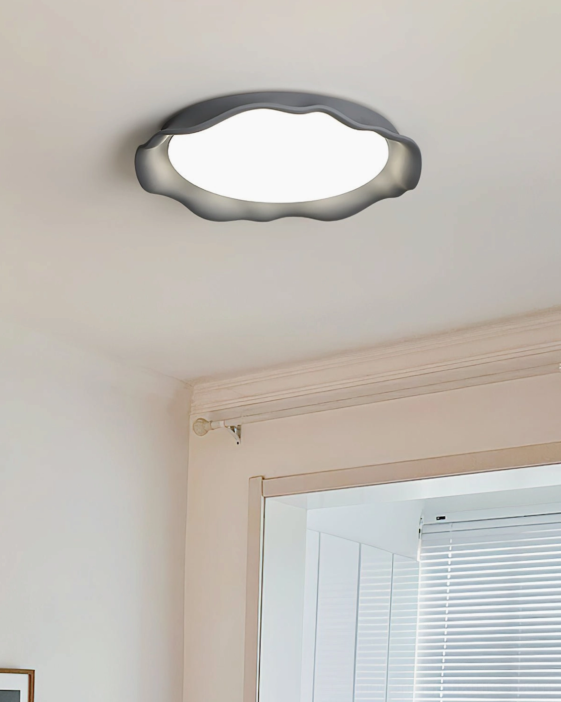 Elio wavy rim ceiling fixture with black outer frame and white light panel, installed in contemporary hallway with window blinds