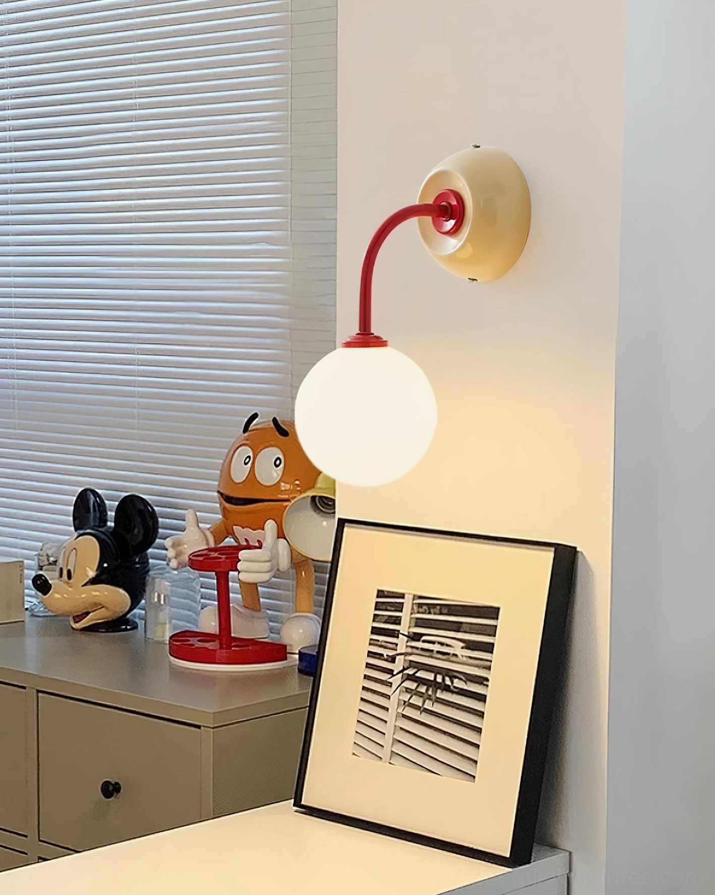 Elio globe wall lamp showing metal base finish and curved arm geometry