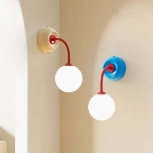 Two Elio wall sconces installed side by side on curved arch wall, blue and beige base variants with red arms