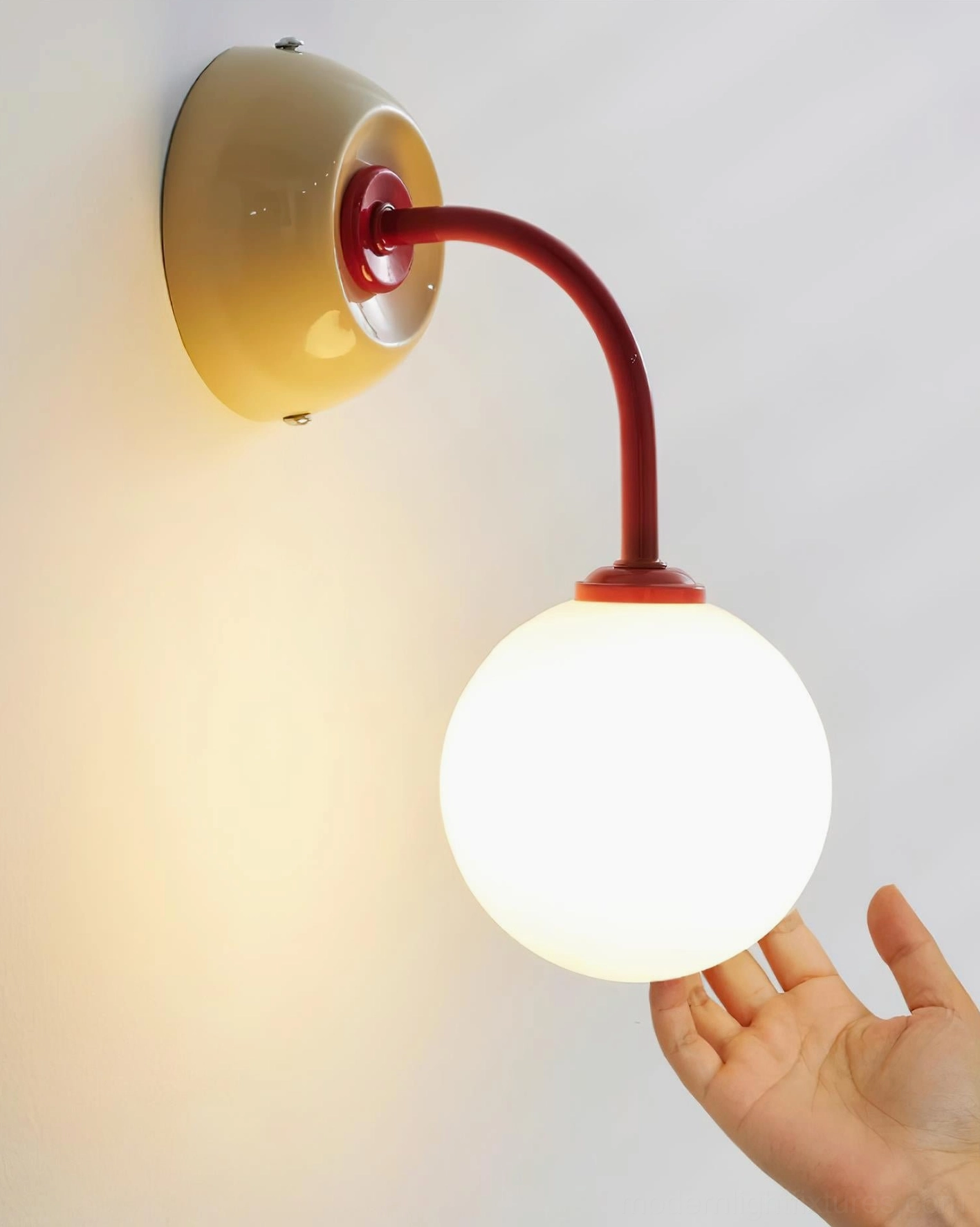 Elio globe wall sconce ambient lighting effect with warm diffused glow from frosted shade