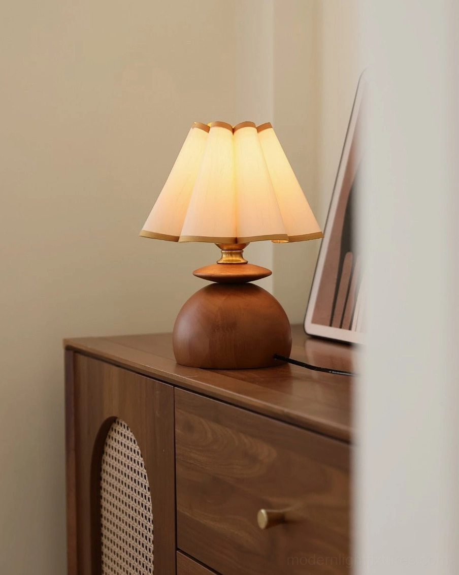 Elmora decorative table lamp on bedroom dresser displaying warm wood finish and lit fabric shade in mid-century modern style