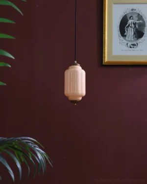 Vintage blush pink ribbed glass pendant light with bronze accents hanging in interior setting