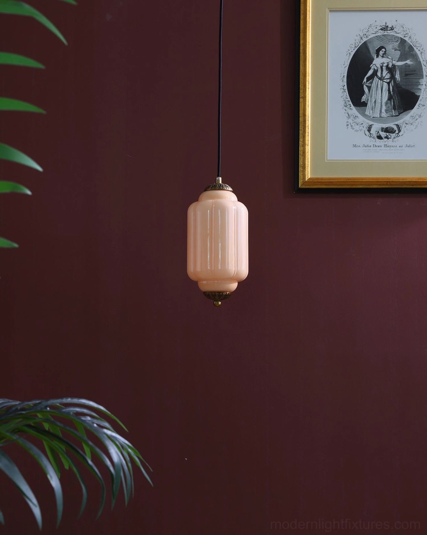 Vintage blush pink ribbed glass pendant light with bronze accents hanging in interior setting