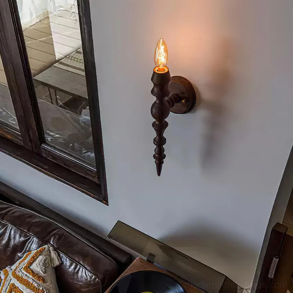 Eloise wood wall sconce installed in vintage living room with leather sofa and mirror