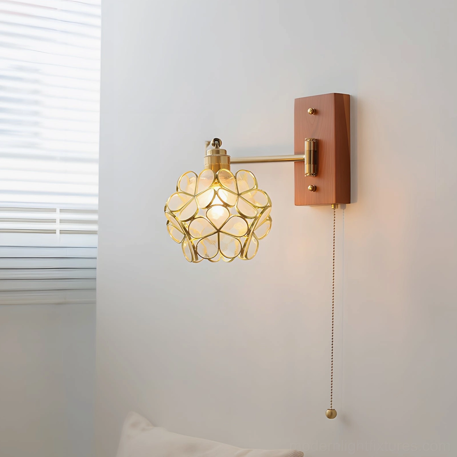 Elowen botanical petal wall lamp ambiance shot, warm light glow from glass shade creating intimate atmospheric lighting in residential space