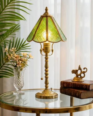 Elowen stained glass lamp displayed on side table with tropical plant and vintage books in home interior