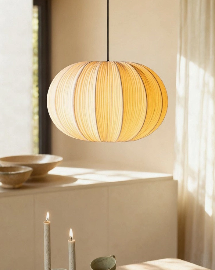 Elunor pleated lantern pendant light glowing warm white light, diffused ambient glow through ribbed fabric