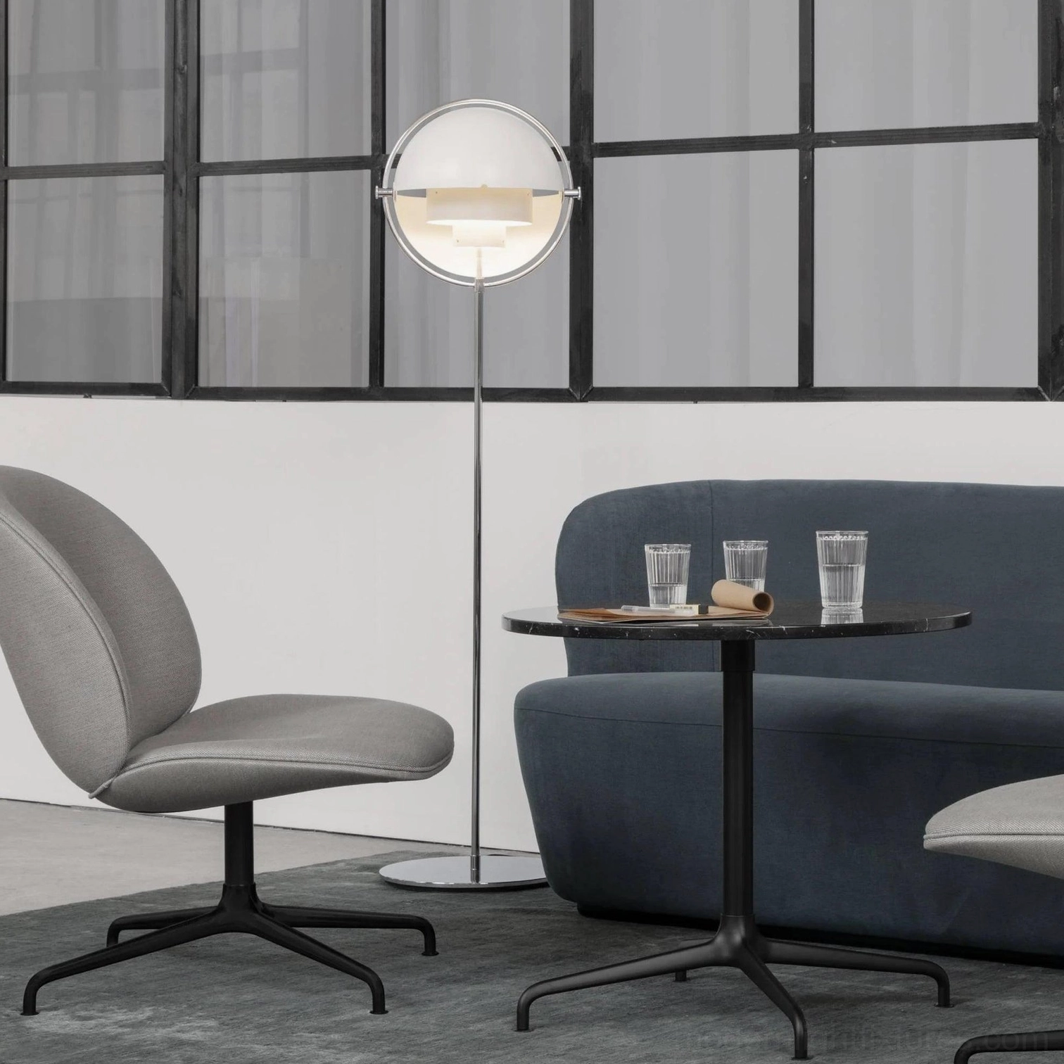 Transparent globe Elvira floor lamp with black metal pole and frosted clear lampshade in Nordic minimalist living room with warm ambient lighting