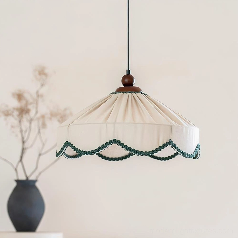 Elysia fabric pendant lamp three-quarter view showing pleated shade and walnut wood cap with green scalloped edge detail